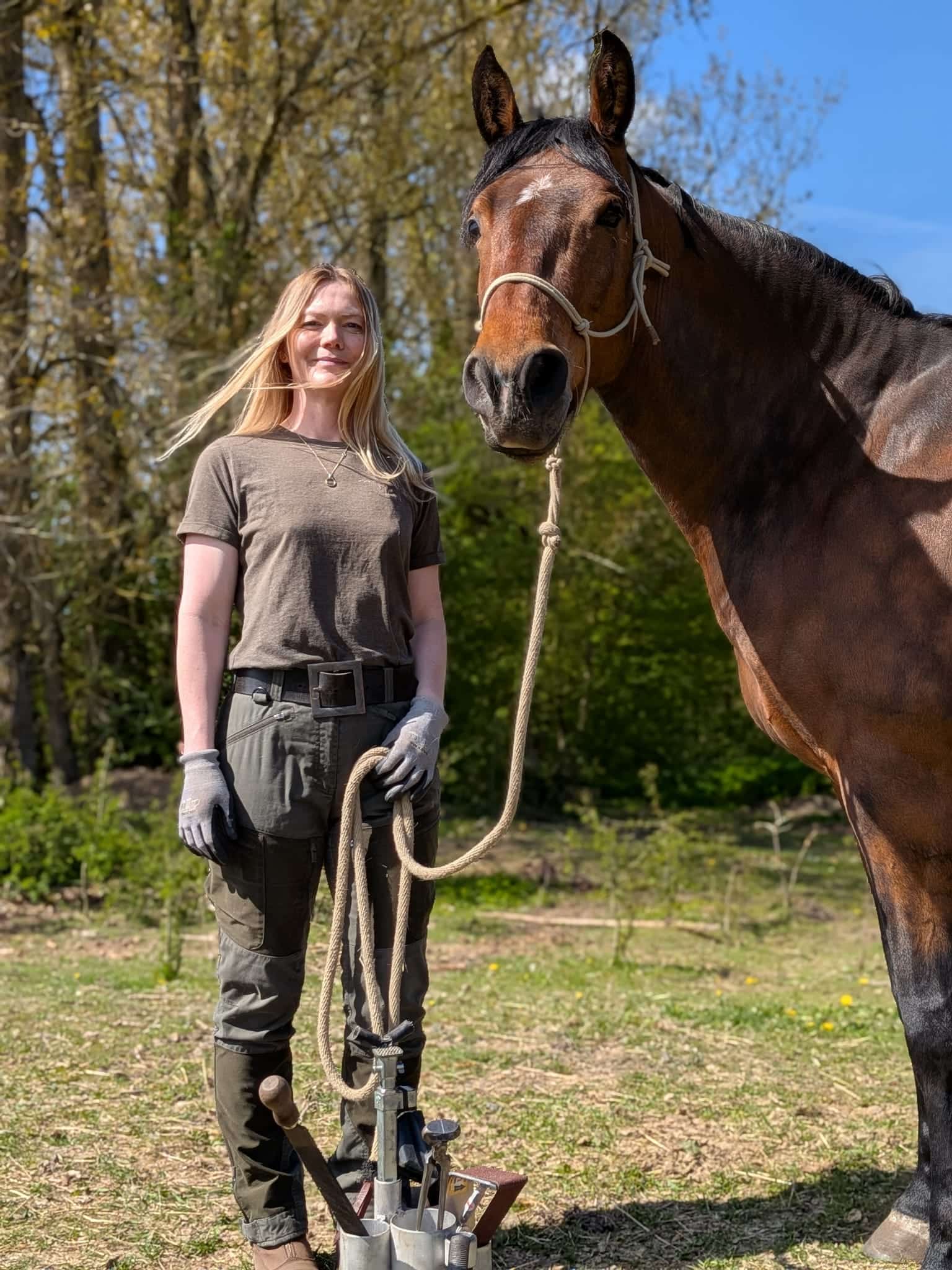 Marlene står med en rolig brun hest